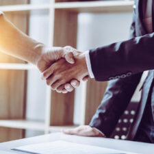 Middle age partner lawyers attorneys shaking hands after discussing a contract agreement done, Asian people.